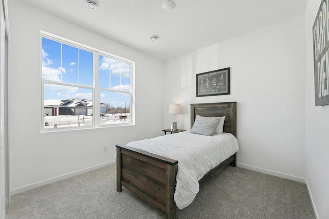 carpeted bedroom with baseboards, multiple windows, and a textured ceiling