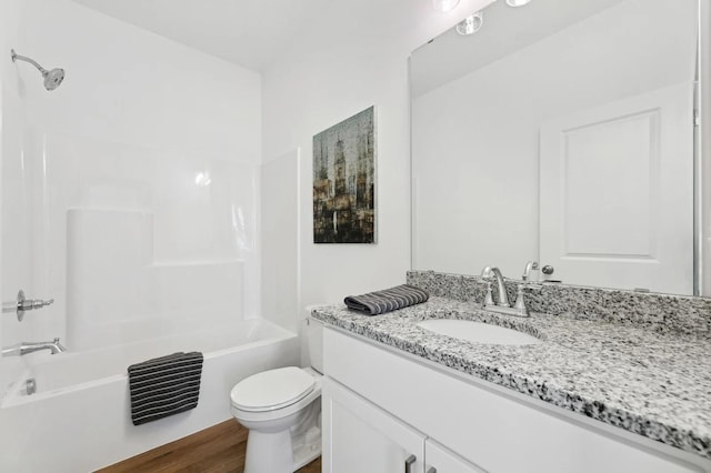 full bathroom with vanity, toilet, wood finished floors, and shower / washtub combination