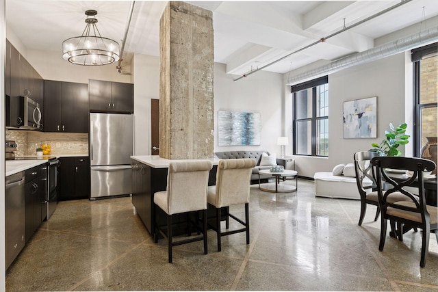 350 Saint Peter St Unit 704, Saint Paul, MN 55102 - kitchen featuring stainless steel appliances, a kitchen breakfast bar, tasteful backsplash, light countertops, and a chandelier