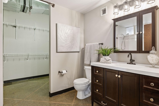 350 Saint Peter St Unit 704, Saint Paul, MN 55102 - full bath featuring toilet, a walk in closet, vanity, a shower, and baseboards