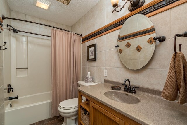 2324 Fair St, Mankato, MN 56001 - full bathroom with vanity, toilet, tile walls, a textured ceiling, and shower / bath combo