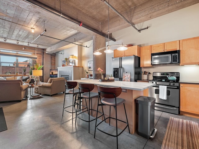 901 3rd St Unit 510, Minneapolis, MN 55401 - kitchen featuring a kitchen island, appliances with stainless steel finishes, finished concrete floors, and light brown cabinets