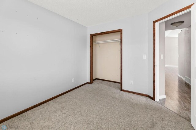 unfurnished bedroom featuring carpet, a closet, and baseboards