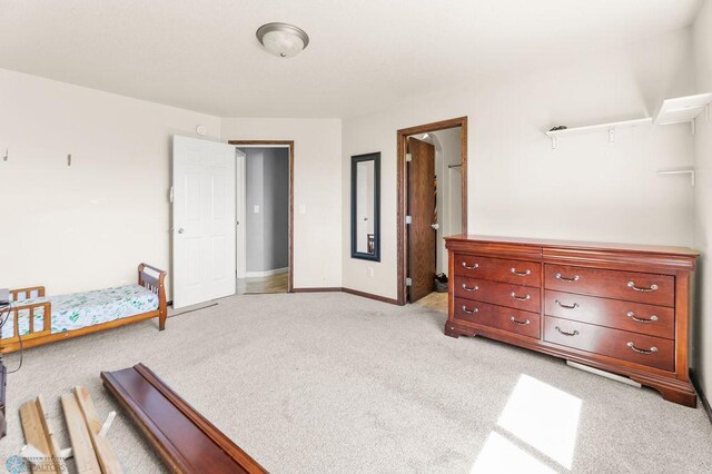 bedroom featuring light colored carpet and baseboards