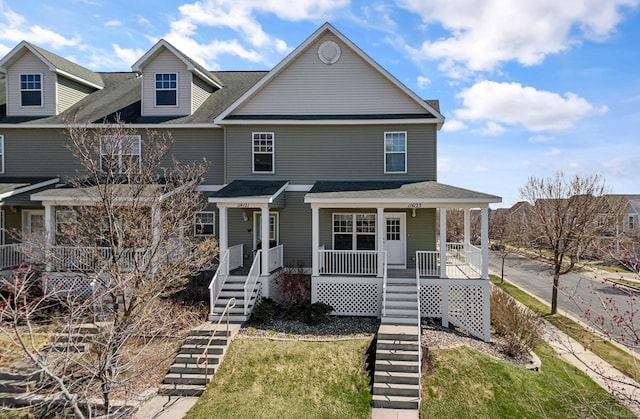 view of front of property with roof with shingles, stairs, and a porch