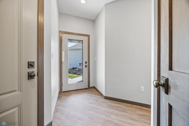 doorway to outside with light wood-style floors and baseboards