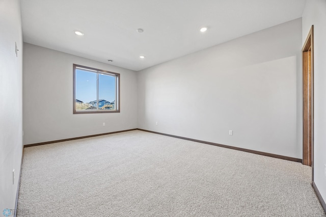 empty room featuring carpet, recessed lighting, and baseboards