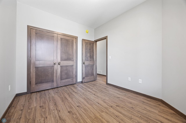 unfurnished bedroom with wood finished floors and baseboards