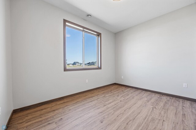 unfurnished room featuring wood finished floors and baseboards