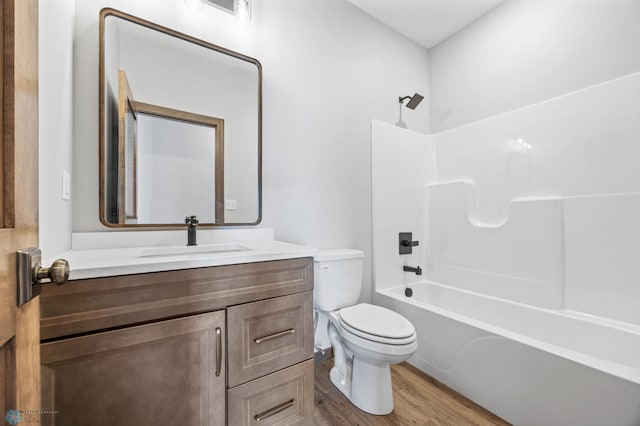 bathroom with wood finished floors, vanity, toilet, and  shower combination