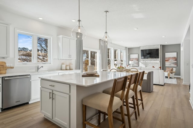 2704 Aspen Dr, Shakopee, MN 55379 - kitchen with stainless steel dishwasher, light countertops, light wood-style floors, plenty of natural light, and recessed lighting
