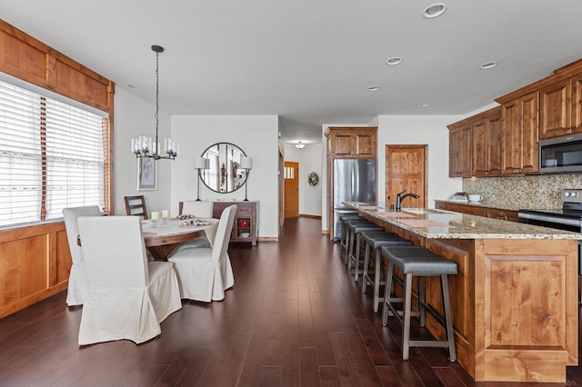 dining room with recessed lighting, an inviting chandelier, and dark wood-type flooring