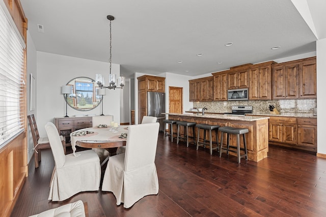 dining room featuring plenty of natural light, dark wood finished floors, and a chandelier