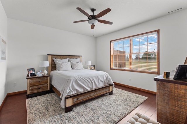 bedroom with visible vents, a ceiling fan, baseboards, and wood finished floors