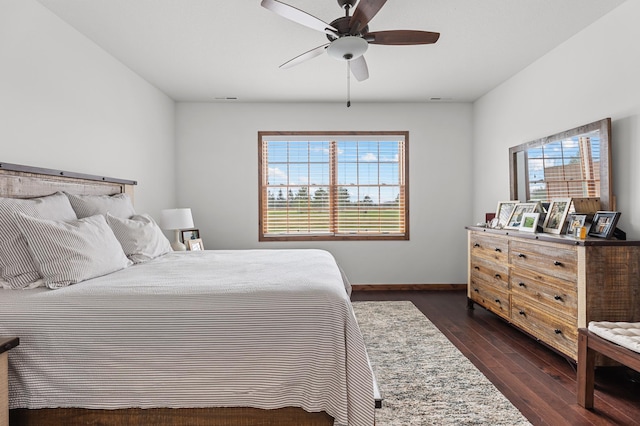 bedroom featuring baseboards, multiple windows, a ceiling fan, and dark wood-style floors