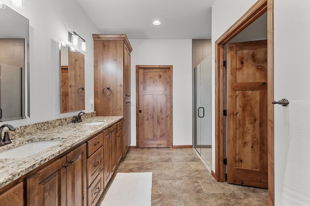 bathroom featuring a sink, a shower stall, and double vanity