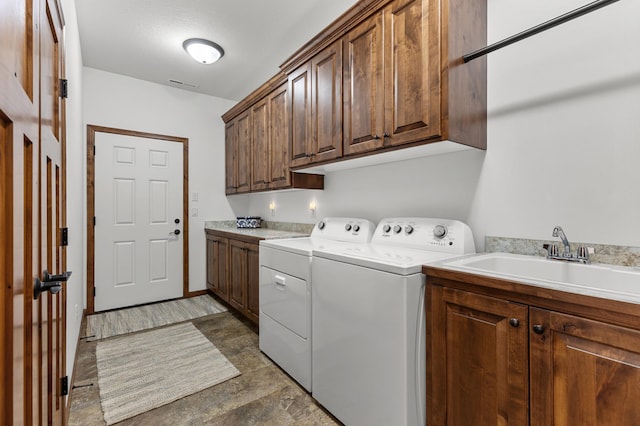 clothes washing area featuring visible vents, a sink, cabinet space, and independent washer and dryer