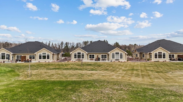 back of house with a patio and a lawn