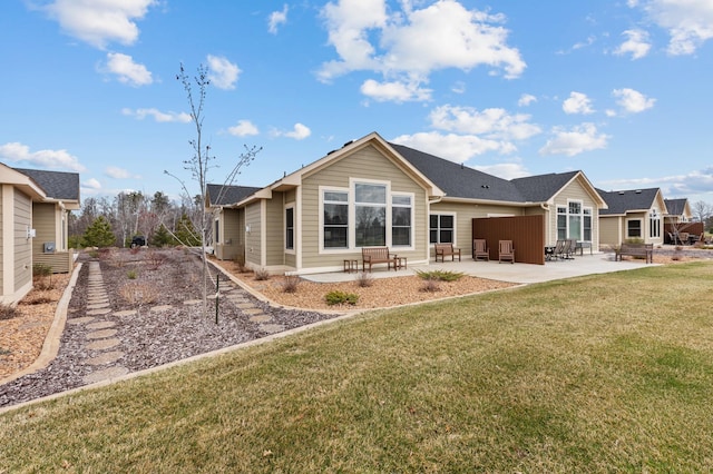 rear view of property featuring a lawn and a patio area