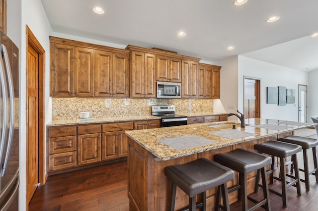 7466 Fairway Ln, Breezy Point, MN 56472 - kitchen with stainless steel appliances, brown cabinets, backsplash, a breakfast bar, and dark wood-type flooring