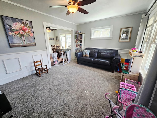 822 4th Ave, Madison, MN 56256 - living room featuring a wainscoted wall, ornamental molding, a ceiling fan, and carpet flooring