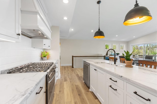 3124 Linden Cir NW, Prior Lake, MN 55372 - kitchen featuring appliances with stainless steel finishes, light wood finished floors, premium range hood, a sink, and white cabinets