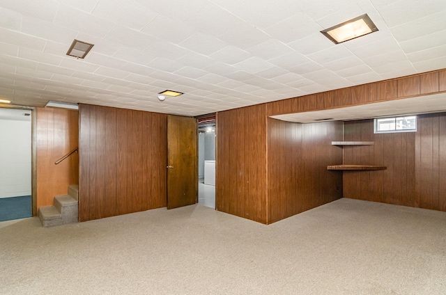 basement featuring stairs, wood walls, and carpet floors