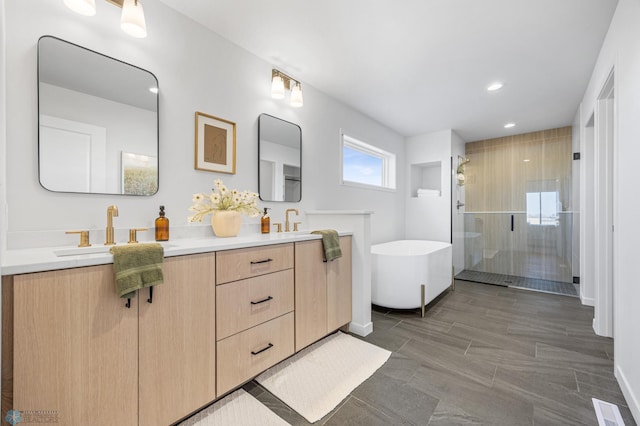bathroom with double vanity, a sink, a freestanding tub, and a shower stall