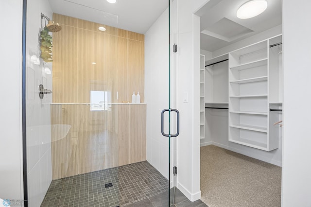 bathroom featuring a walk in closet and a shower stall