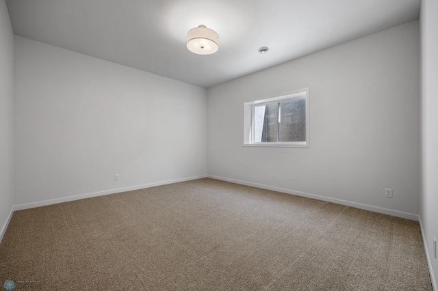 carpeted empty room with baseboards