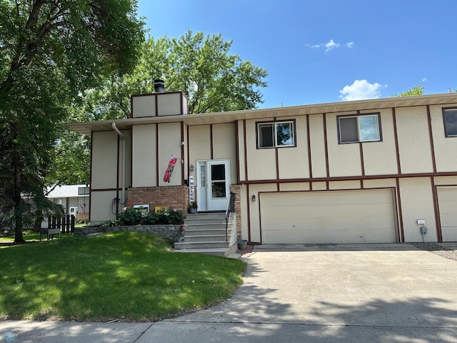 2323 4th Ave S, Moorhead, MN 56560 - bi-level home with a garage, concrete driveway, a chimney, and a front yard