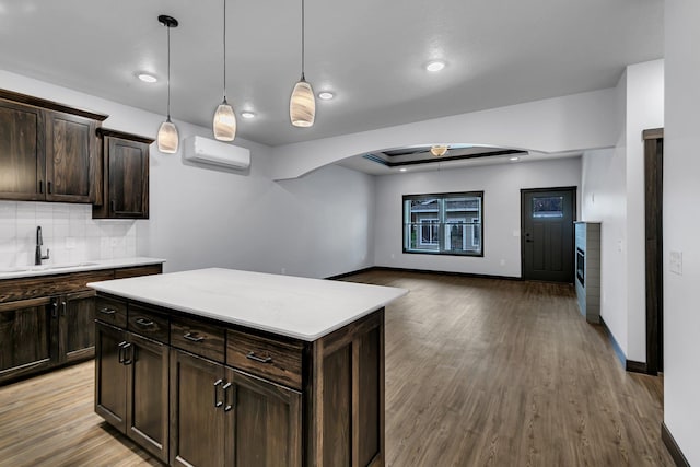 215 Butler St, Litchfield, MN 55355 - kitchen with a wall mounted air conditioner, light countertops, backsplash, wood finished floors, and a ceiling fan