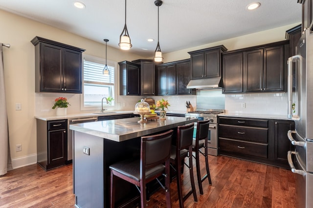 19717 Hazel Nut Ave, Lakeville, MN 55044 - kitchen featuring appliances with stainless steel finishes, under cabinet range hood, recessed lighting, a sink, and dark wood finished floors