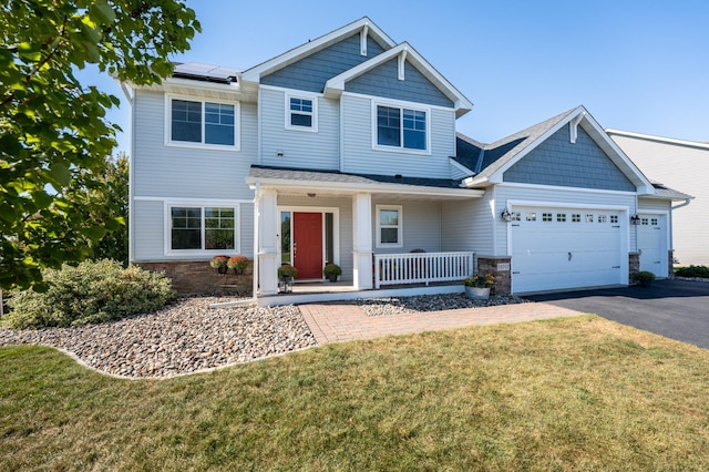 19717 Hazel Nut Ave, Lakeville, MN 55044 - view of front of property featuring a porch, asphalt driveway, roof mounted solar panels, a front lawn, and a garage