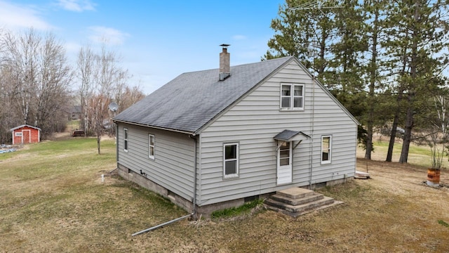 37301 Little Sweden Rd, Nashwauk Twp, MN 55769 - back of property with a shingled roof, an outbuilding, a chimney, and a lawn