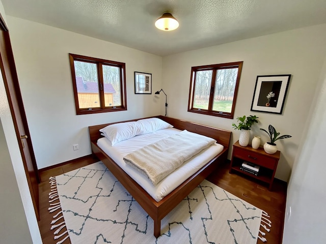 777 Big Round Ave, Georgetown Twp, WI 54853 - bedroom with a textured ceiling, wood finished floors, and multiple windows