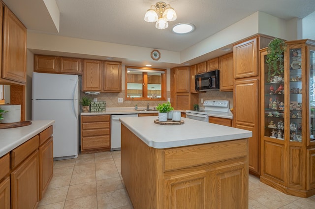 kitchen with white appliances, a sink, backsplash, and light countertops