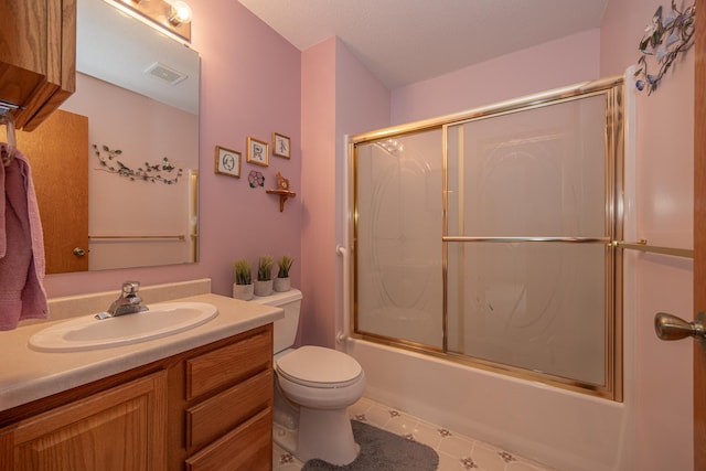 bathroom featuring vanity, shower / bath combination with glass door, toilet, and tile patterned floors