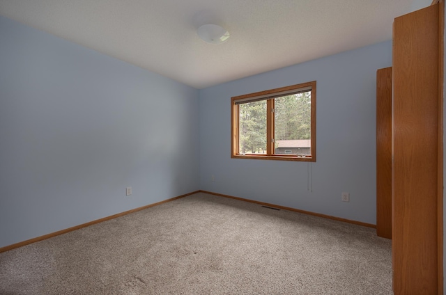 carpeted spare room with baseboards
