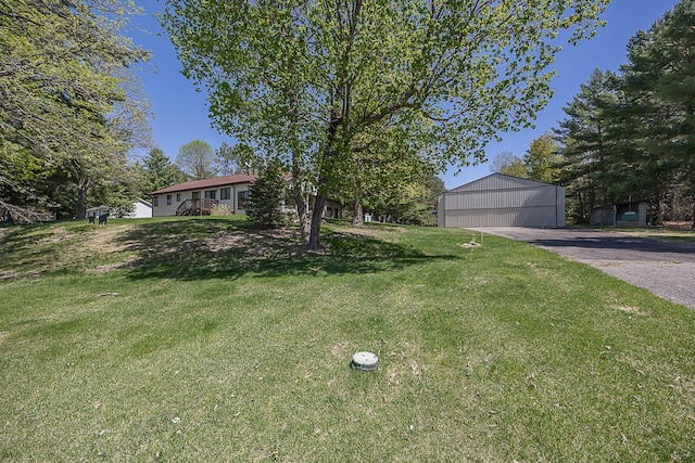 view of front facade with a front yard, an outbuilding, and a garage