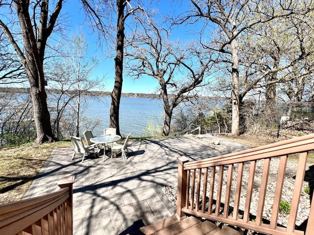 deck featuring a water view and outdoor dining area