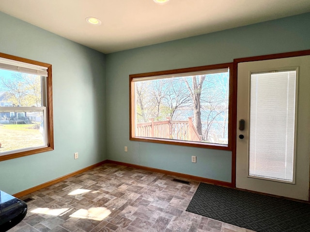interior space featuring baseboards, recessed lighting, visible vents, and stone finish floor