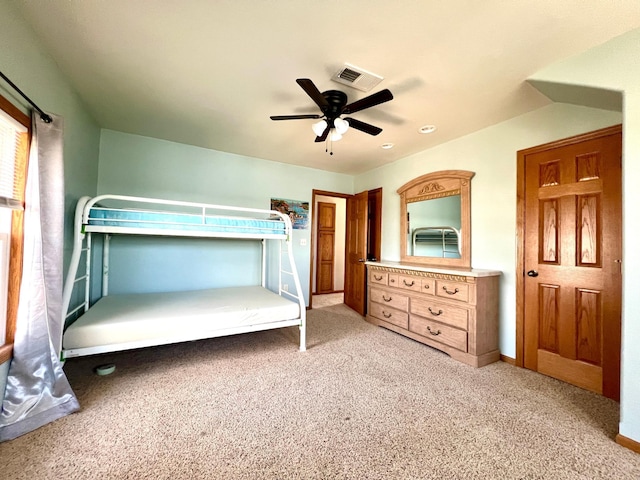 unfurnished bedroom with baseboards, visible vents, ceiling fan, and light colored carpet