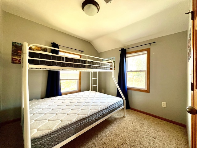 bedroom with carpet floors, baseboards, vaulted ceiling, and multiple windows