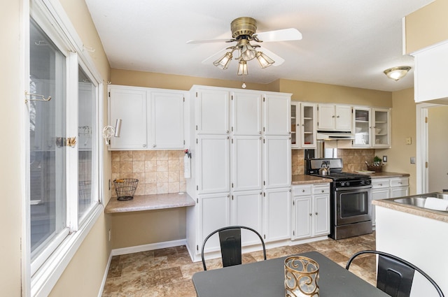 kitchen featuring stainless steel range with gas stovetop, ceiling fan, under cabinet range hood, and white cabinetry