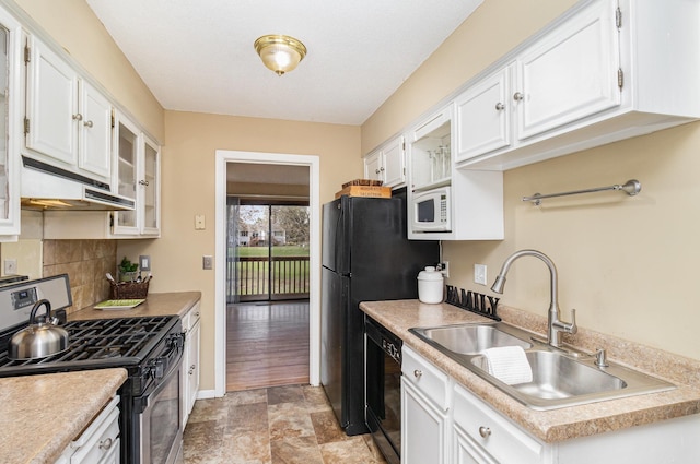 kitchen with a sink, stainless steel gas stove, black dishwasher, white cabinetry, and under cabinet range hood