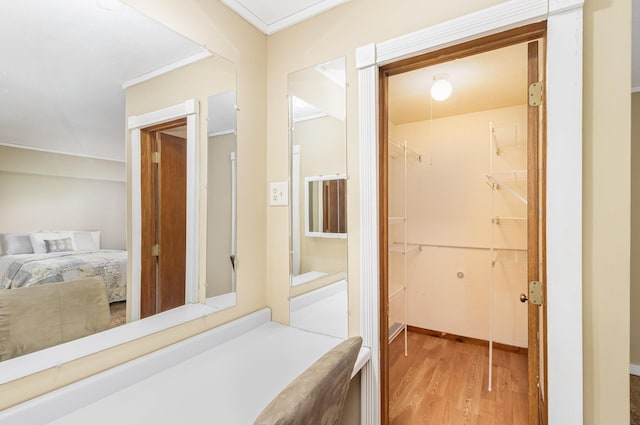 hallway with ornamental molding and wood finished floors