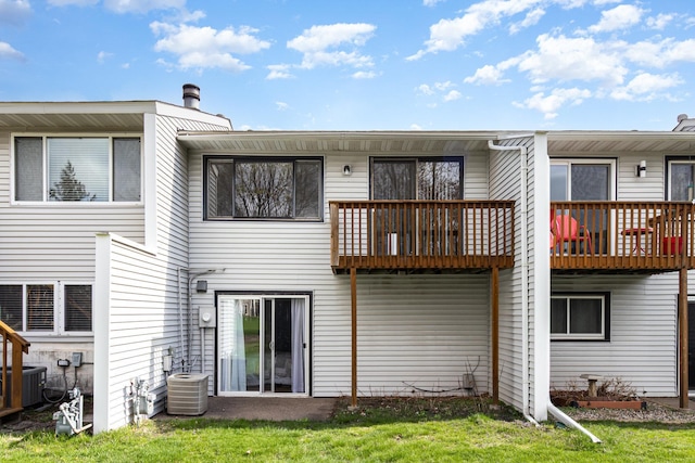 back of property with central AC unit, a yard, and a balcony