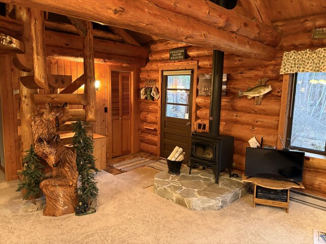 carpeted living area with a healthy amount of sunlight, log walls, a wood stove, and lofted ceiling