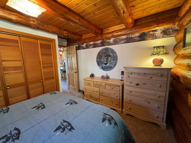 carpeted bedroom with a closet, wood ceiling, and beam ceiling